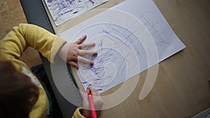 Little beautiful girl draws at the desk