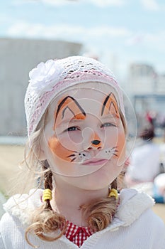 Little beautiful girl with face painting of orange fox