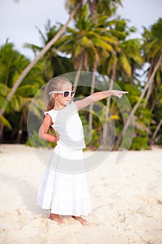 Little beautiful girl in a long dress on tropical