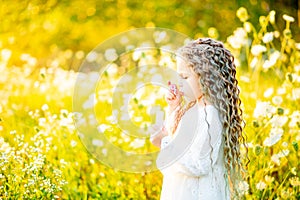 Little beautiful girl playing on the lawn in summer with soap bubbles