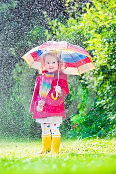 Little beautiful girl playing in the rain