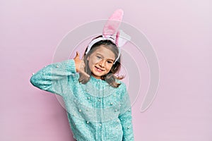 Little beautiful girl wearing cute easter bunny ears smiling doing phone gesture with hand and fingers like talking on the