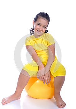 Little beautiful girl in yellow with yellow ball