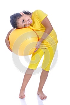 Little beautiful girl in yellow with yellow ball