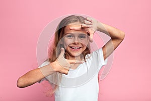 Little beautiful happy girl making frame with hands and fingers