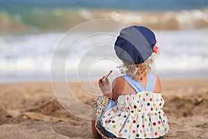 Little beautiful happy girl siting on beach