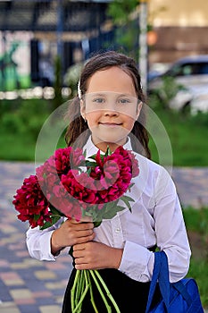 little beautiful schoolgirl in a white shirt with flowers