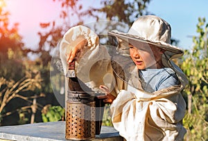 Little beekeeper blows smoker for bees