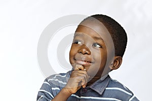 Little black boy thinking with hand on his chin