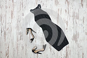 Little black dress and shoes. Wooden background, fashionable con