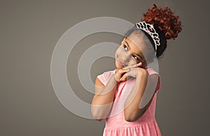 Little black girl dreaming, wearing tiara