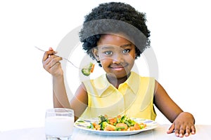 Little black girl eating healthy vegetable meal.