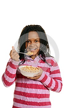 Little black girl enjoying bowl of cereal