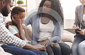 Little black girl and her parents at psychologist consultation