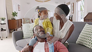 Little black girl playing with parents at home