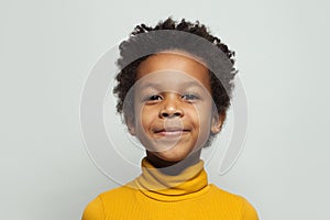 Little black kid boy smiling on white background, close up portrait