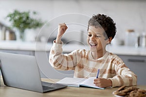 Little Black Schoolboy Using Laptop And Celebrating Success At Home