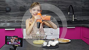 Little blogger concept. A 6-7 year old girl tells and shows how to make an omele