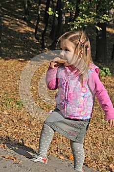 Little blond girl eating biscuit