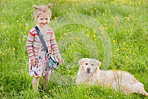 A little girl with her pet dog outdooors in park