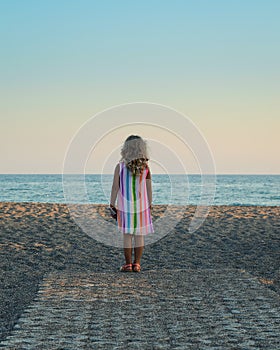 Little blond girl looking at the sea