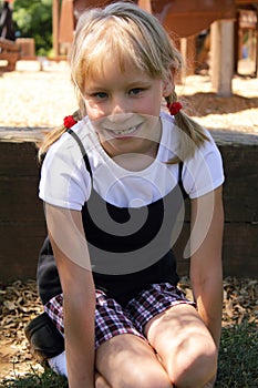 Little Blond Girl Playing in a Playground