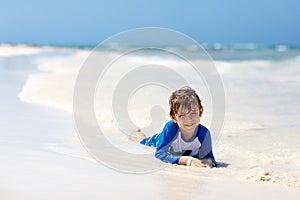 Little blond kid boy having fun on tropical beach of Jamaica
