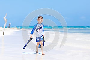 Little blond kid boy having fun on tropical beach of Jamaica