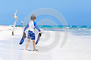Little blond kid boy having fun on tropical beach of Maldives
