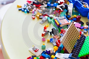 Little blond kid boy playing with lots of colorful plastic block
