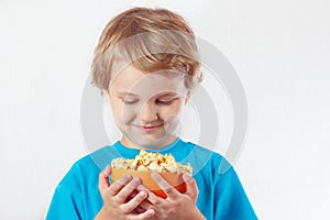 Little blonde boy looking for a bowl of popcorn