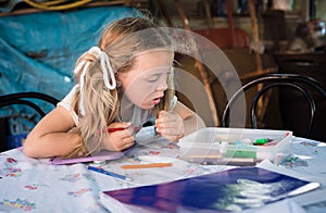 Little blonde girl drawing with crayons