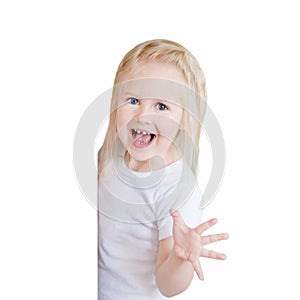 The little blonde girl with long hair in a white t-short.The girl in peek from behind the door and intends to frighten