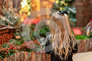 Little blonde girl looking at holiday lights