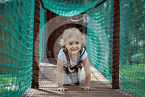 Little blonde girl in the rope park.