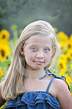 Little blonde girl in sunflower field