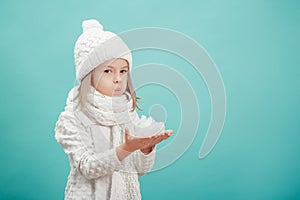 Little blonde girl in a white hat and scarf