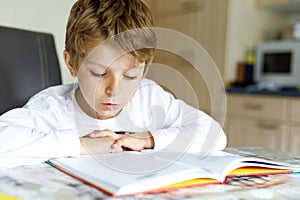 Malý blondínka dieťa chlapec čítanie kniha na 