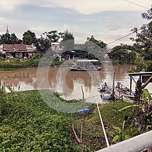 A little boat cross the river when afternoon come