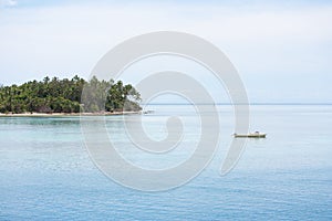 A little boat and a tropical island in Tonga