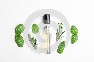 Little bottle of essential oil with different herbs on white background
