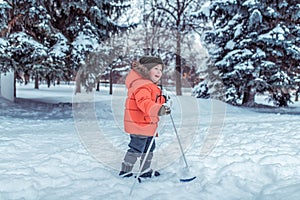 Little boy 3-4 years old, winter children`s skis, happy smiling plays, having fun, active image of children. Background