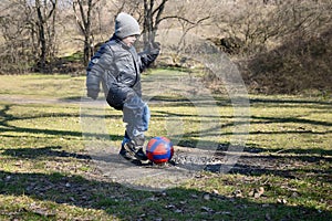 Little boy 6-7 years hits the ball to score a goal