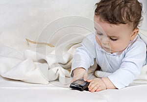 The little boy of 7 months plays with a cellular t