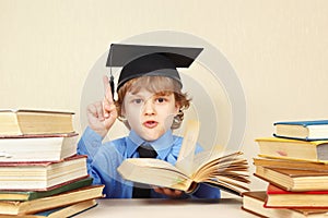 Little boy in academic hat quoted old book