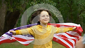 Little boy with american flag hugging military dad, family values, patriotism