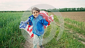 Little boy American patriot kid running with national flag on countryside road.