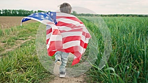 Little boy American patriot kid running with national flag on countryside road.