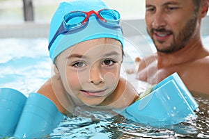 Pequeno chico mangas en nadar piscina 