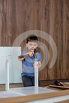 Little Boy assembling furniture. Furniture repair and assembly